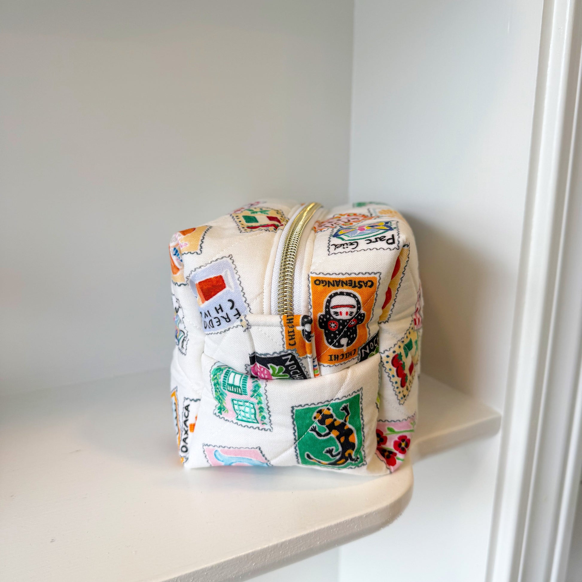 Small pouch with colorful patches on a white shelf