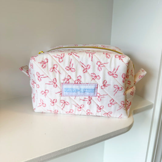Small pouch with pink floral pattern on a white shelf